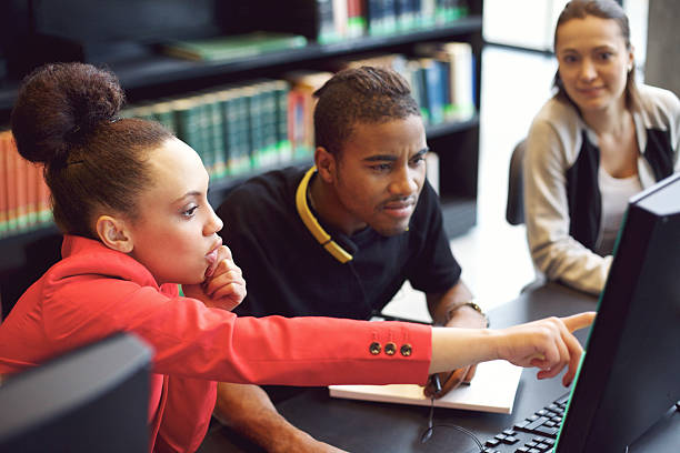 Group of students doing online research in library