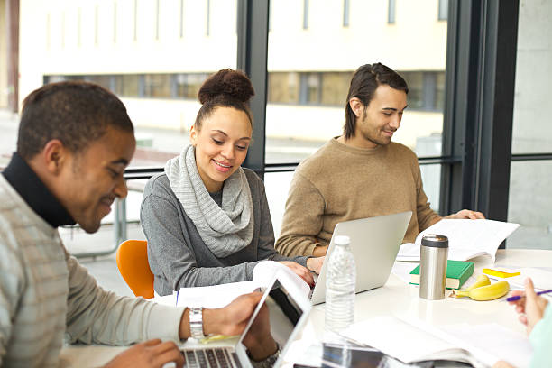 istock Young students studying in university library with books and laptop 486076097