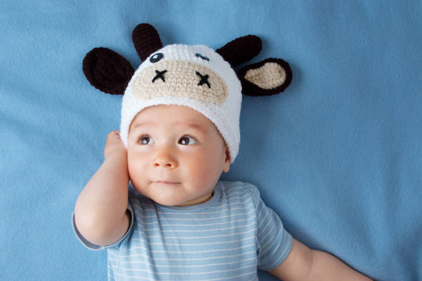 istock Baby in a cow hat on blue blanket 486077358