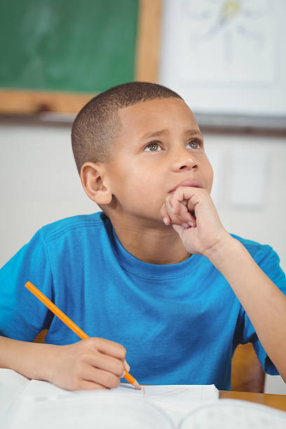 istock Concentrated pupil working at his desk in a classroom 486078098