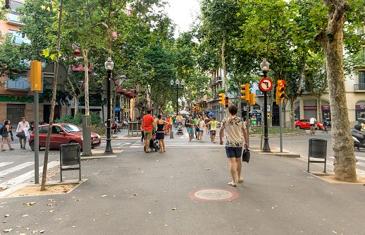 Barcelona, Spain - July 5, 2015: Crowded La Rambla street at the heart of Barcelona, Spain. People are walking by street.