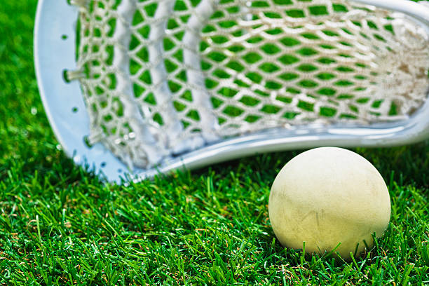 istock White ball and white Lacrosse stick on artificial turf 486086572