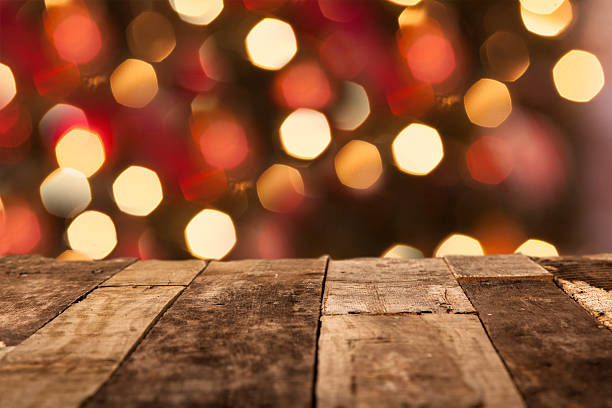 istock Christmas tree, holiday lights behind wooden table. Copyspace. 486086732