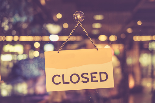 A closed sign hanging in a shop window