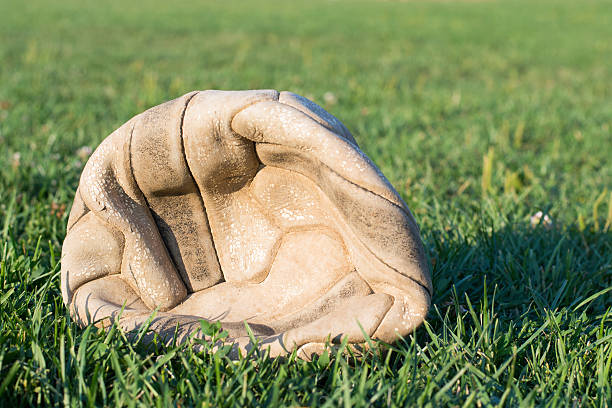 古いしぼんだサッカーボールサッカーフィールドの芝生 - soccer ball old leather soccer ストックフォトと画像