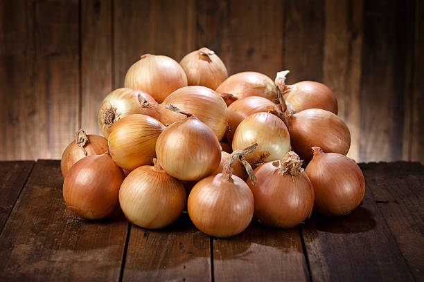 istock Big pile of raw organic onions on rustic wood table 486093450