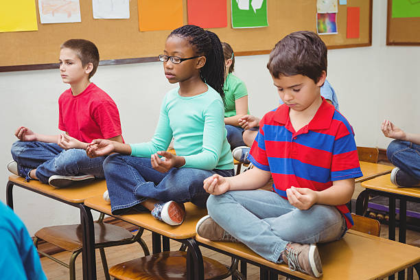 istock Pupils meditating on classroom desks 486094060