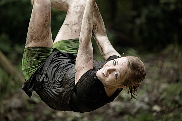 istock woman hanging on rope during obstacle run 486095252