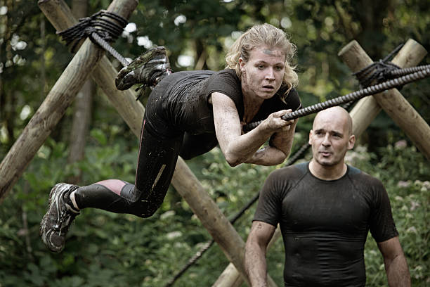 istock man looking at  woman crossing rope obstacle 486095294