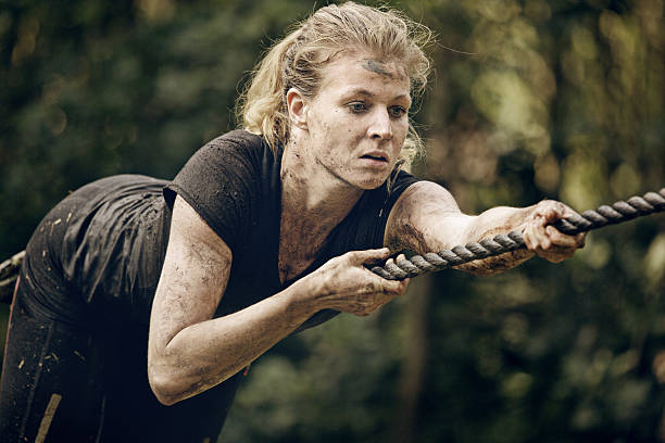 istock woman climbing rope during obstacle run 486095306