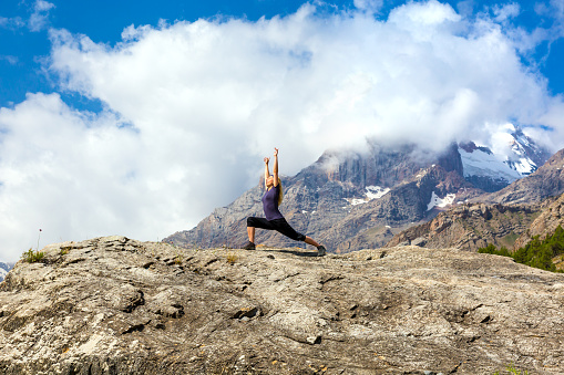 Female Rock Climber Doing Yoga Fitness to Stretch Body Mountain Panoramic Landscape Outdoor Sunny Sky Peaks