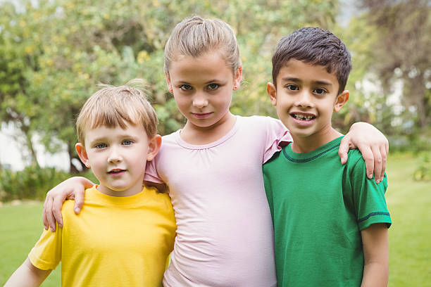 istock Happy children standing together with arms around each other 486106406