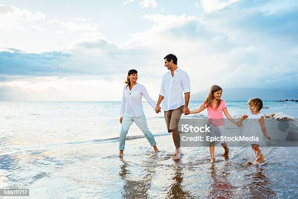 Happy Young Family Walking On The Beach Stock Photo - Download Image Now - Family, Beach, Walking