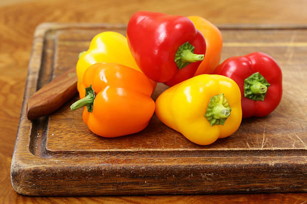 istock Fresh organic bell peppers on a wooden board 486112334