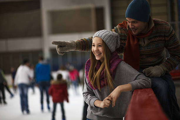 Dad and daughter ice skating,indoor