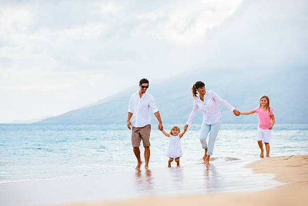 istock Happy young family walking on the beach 486114809