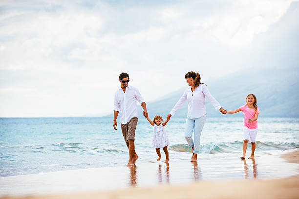 istock Happy young family walking on the beach 486114811