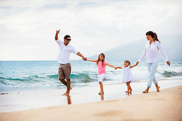 istock Happy young family walking on the beach 486114813