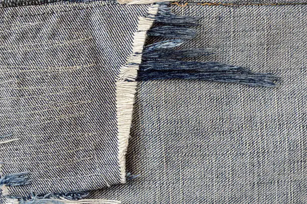 close up ragged fabric of old bluejeans