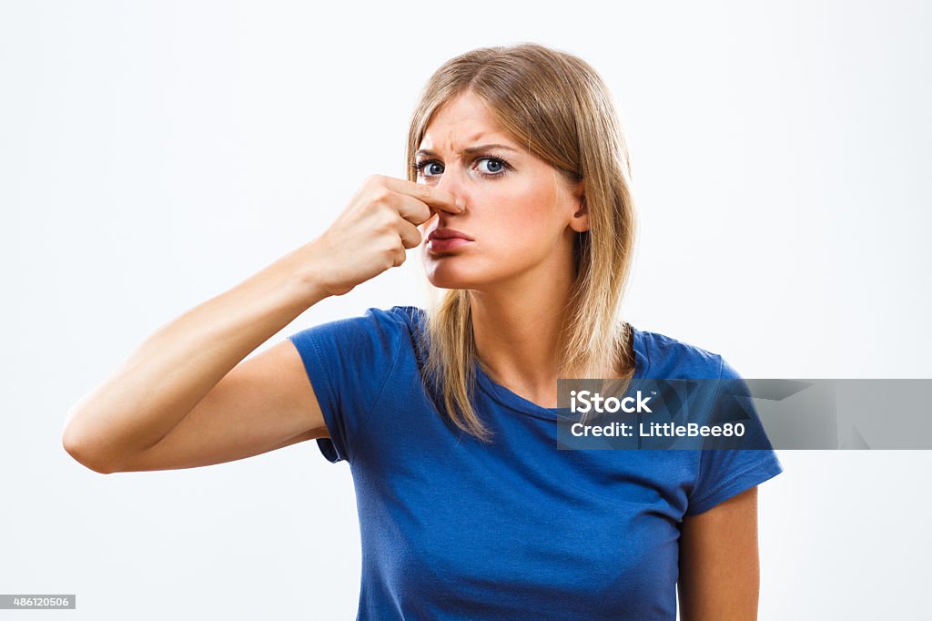 Unpleasant smell Young  woman doesn't like how something smells. Holding Nose Stock Photo