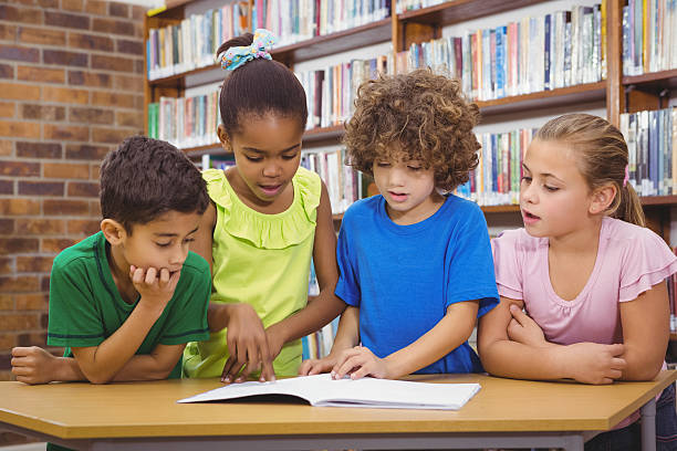 studenti lettura libro froma scuola - primary colours foto e immagini stock