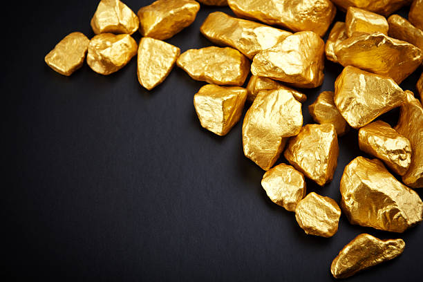 gold nuggets on a black background. closeup. gold nuggets on a black background. closeup. ingot photos stock pictures, royalty-free photos & images