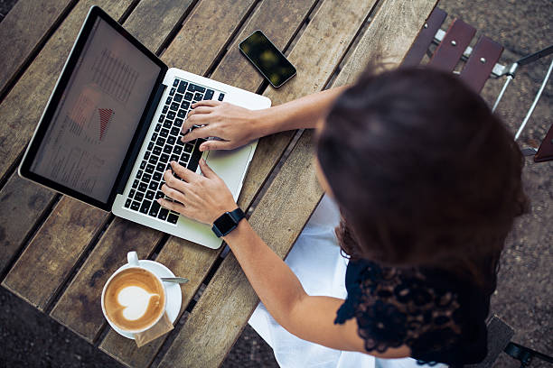 istock Woman using her laptop at a coffee shop 486125780