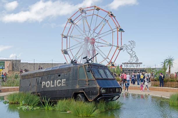 Water Cannon fountain Weston-Super-Mare, UK - August 26, 2015:  A former crowd control police van with water cannon from Northern Ireland now converted to a fountain, there's a water slide at the other side.  Part of the parody seaside attractions at the traditional seaside resort at Weston-Super-Mare. banksy stock pictures, royalty-free photos & images