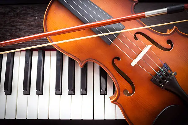 Photo of Violin on piano keyboard.