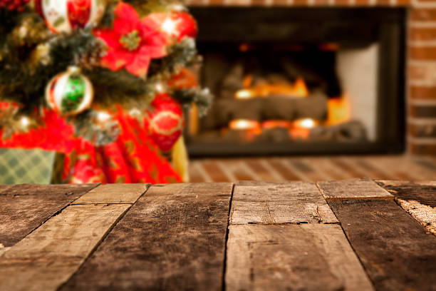 istock Holiday backgrounds.  Christmas tree, fireplace with rustic wooden table. 486129332
