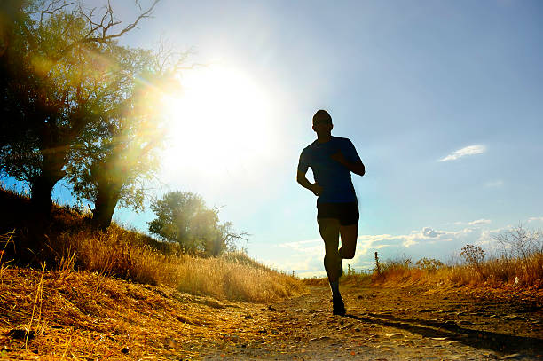 istock front silhouette sport man running cross country at summer sunset 486132284