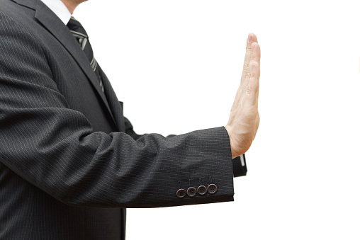 Businessman showing stop sign on white background