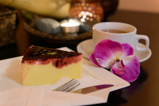 Blueberry cheese cake and herbal tea with spa elements as background