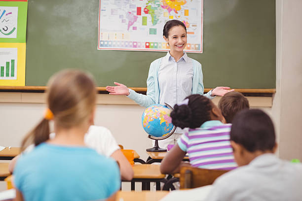 istock Pupils listening to their teacher at chalkboard 486138510