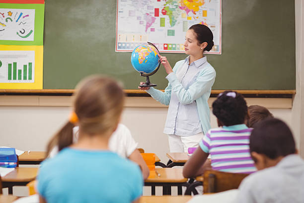 istock Pupils listening to their teacher holding globe 486138518