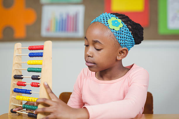 istock Focused pupil calculating with abacus in a classroom 486138776