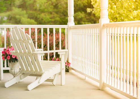 A lovely and peaceful front porch with white Adirondack chairs.
