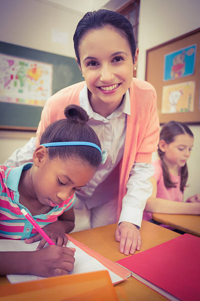 istock Pupil and teacher at desk in classroom 486140120