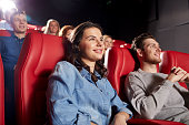 happy friends watching movie in theater