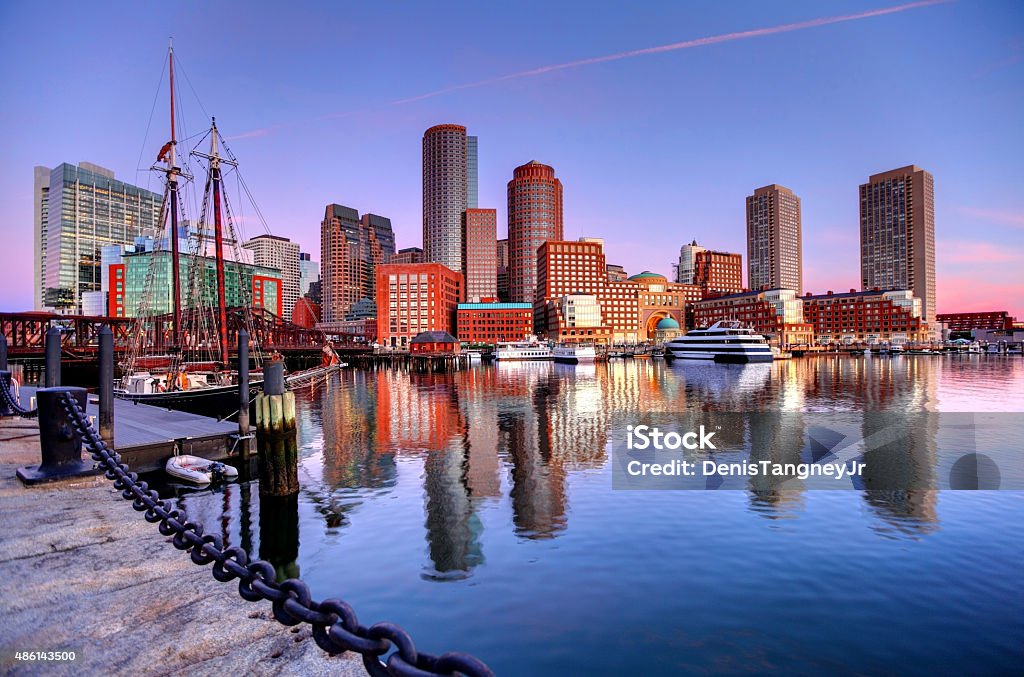 Boston Skyline along the Harborwalk Downtown Boston Skyline along the Boston Harbor Waterfront. Photo taken along the harborwalk in the  South Boston southie neighborhood. The Boston cityscape is a mixture of old and new buildings. Boston is the capital and largest city in Masssachusetts. Boston is the largest city in New England  Boston - Massachusetts Stock Photo