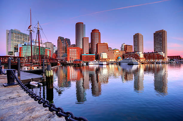 Boston Skyline along the Harborwalk Downtown Boston Skyline along the Boston Harbor Waterfront. Photo taken along the harborwalk in the  South Boston southie neighborhood. The Boston cityscape is a mixture of old and new buildings. Boston is the capital and largest city in Masssachusetts. Boston is the largest city in New England  harborwalk stock pictures, royalty-free photos & images