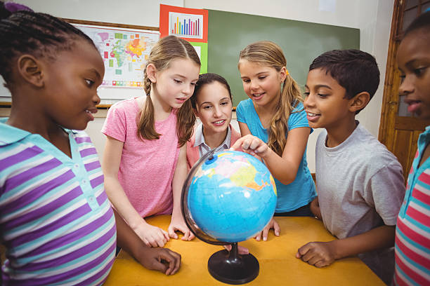 istock Teacher and pupils looking at globe 486144888