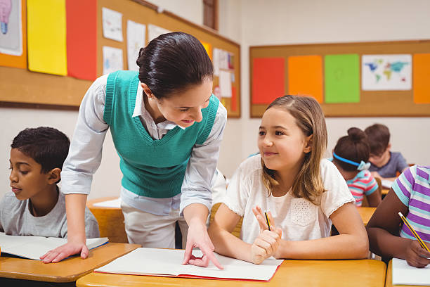 istock Teacher helping a little girl during class 486148430