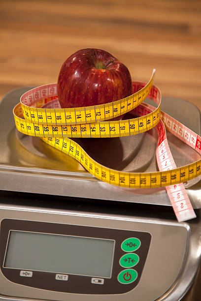 istock Tape measure and apple on a scale. 486148952