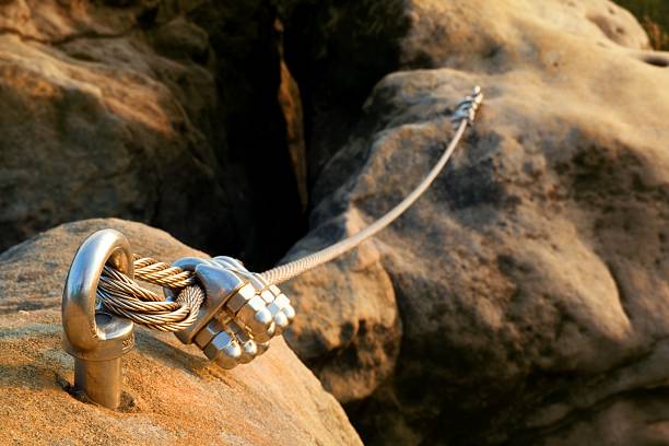 Iron twisted rope streched between rocks in climbers patch. stock photo