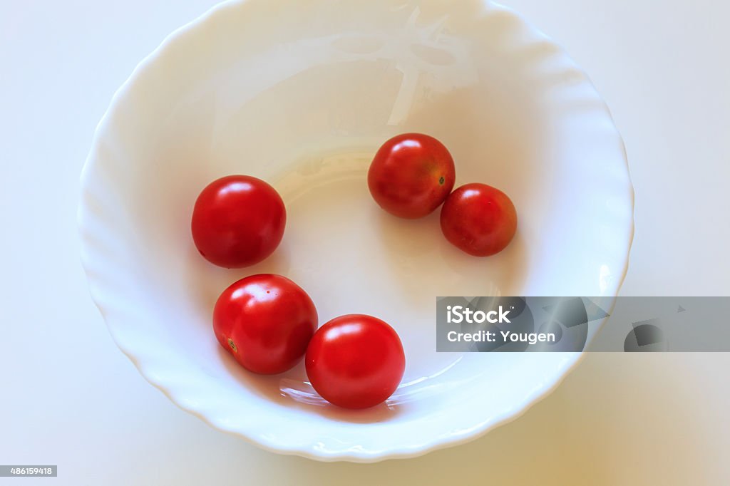 Vermelho brilhante tomate cereja em uma tigela branca - Foto de stock de 2015 royalty-free