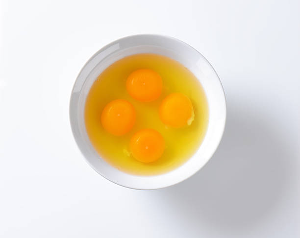 egg yolks bowl of raw egg yolks isolated on white background egg yolk on white stock pictures, royalty-free photos & images