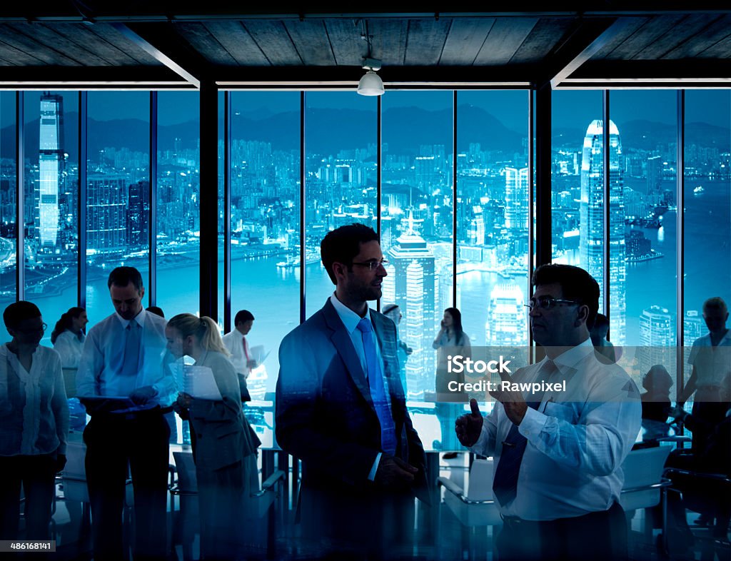 Uomini d'affari al lavoro In una sala conferenze - Foto stock royalty-free di Adulto