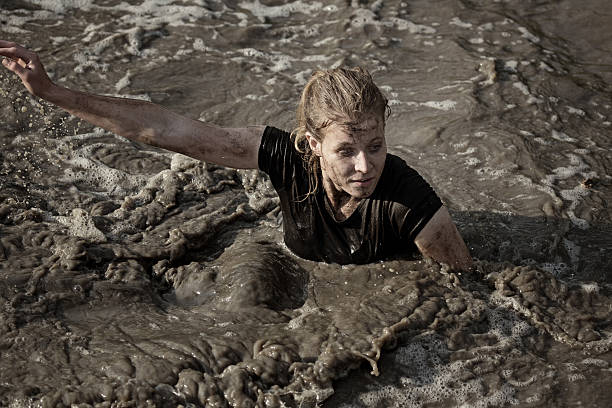 istock woman covered by mud crossing the canal 486168668