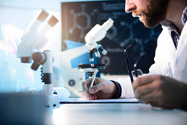 Clipboard A scientist writing on a clipboard ebola stock pictures, royalty-free photos & images